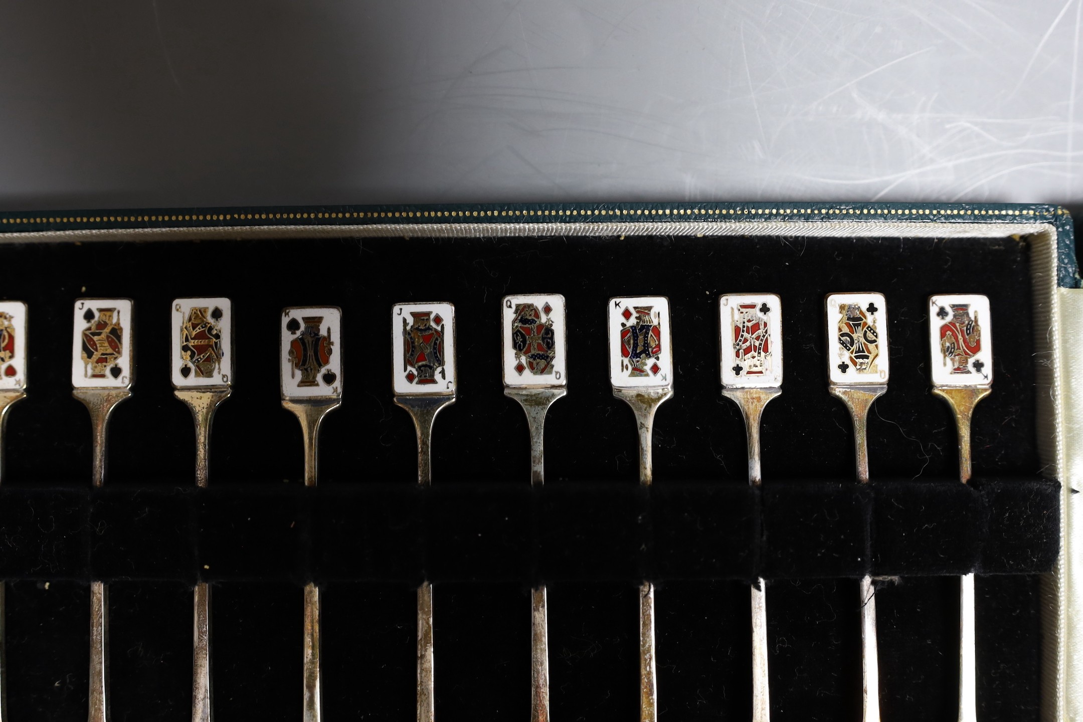 A cased set of twelve early 1960's silver and enamel cocktail sticks, by Garrard & Co, with playing card terminals, Birmingham, 1961.